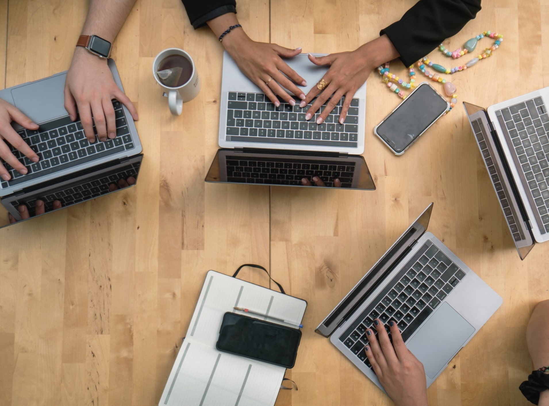 Image features a wood table with laptops on it.